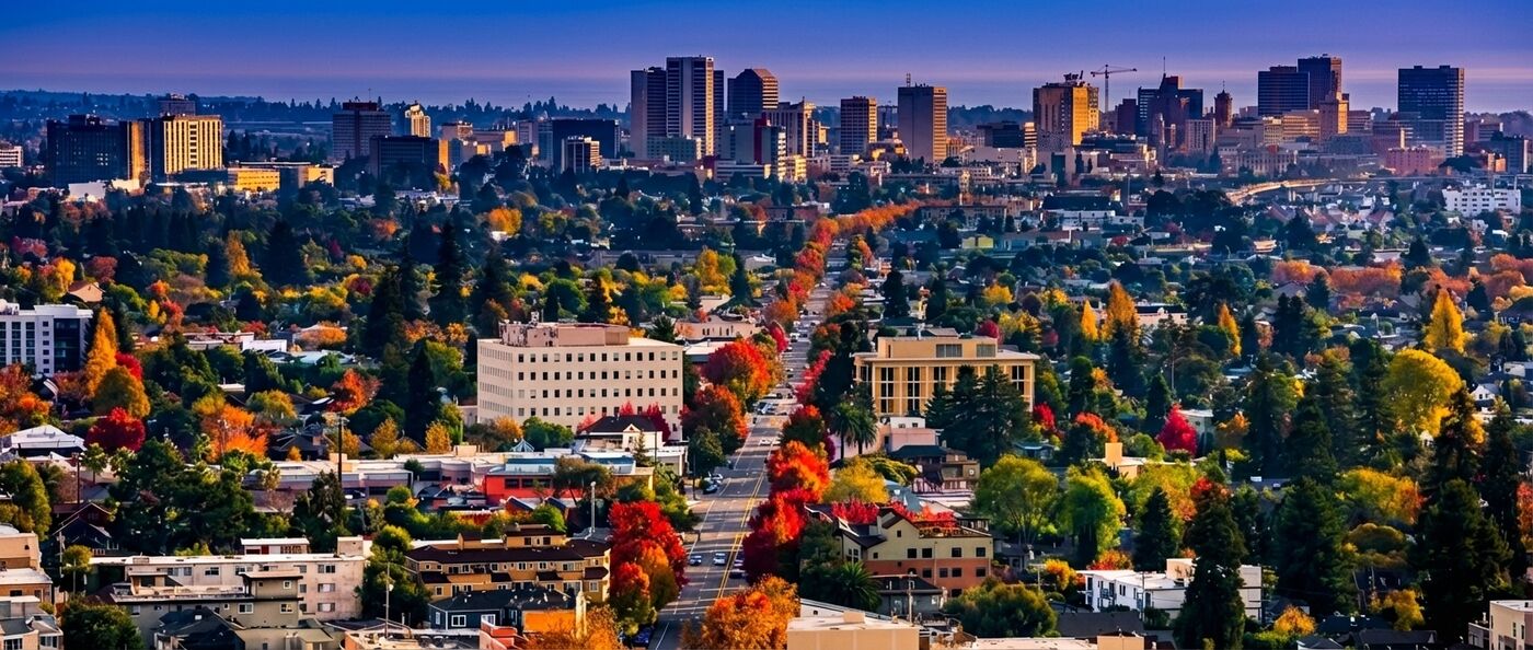 Vista aérea del centro de Oakland en otoño, con el perfil de la ciudad detrás de barrios residenciales